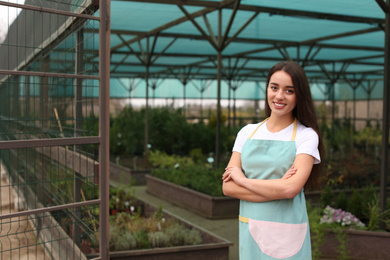 Photo of Female business owner in greenhouse. Space for text