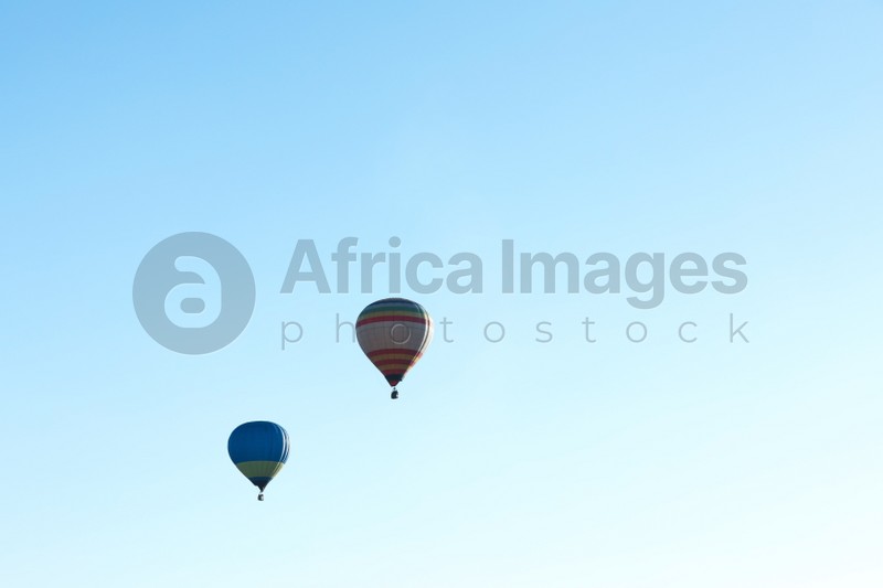 Colorful hot air balloons flying in blue sky. Space for text