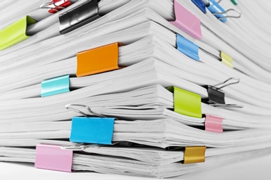 Stack of documents with colorful binder clips, closeup