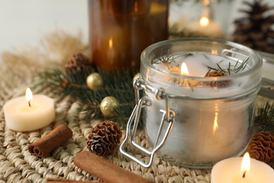 Burning scented conifer candles and Christmas decor on table. Space for text