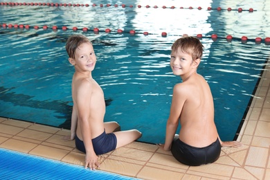 Cute little boys near indoor swimming pool