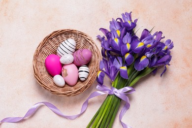 Photo of Flat lay composition with festively decorated Easter eggs and iris flowers on color textured background