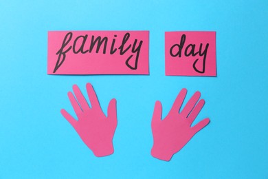Cards with text Family Day and paper palms on light blue background, flat lay