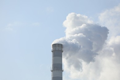 Photo of Polluting air with smoke from industrial chimney outdoors. CO2 emissions