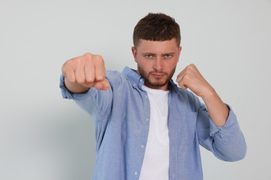 Young man ready to fight on white background
