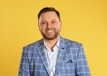 Portrait of happy mature man on yellow background