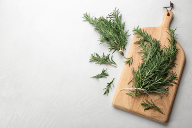 Bunches of fresh rosemary on light table, above view. Space for text