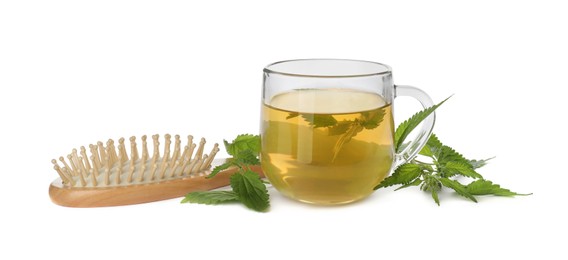Photo of Stinging nettle infusion, green leaves and brush on white background. Natural hair care