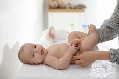 Photo of Mother changing her baby's diaper on table
