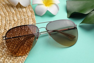 New stylish elegant sunglasses on turquoise background, closeup