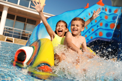 Happy children on slide at water park. Summer vacation