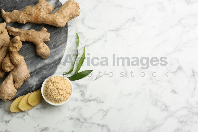 Dry ginger powder, fresh root and leaves on white marble table, flat lay. Space for text