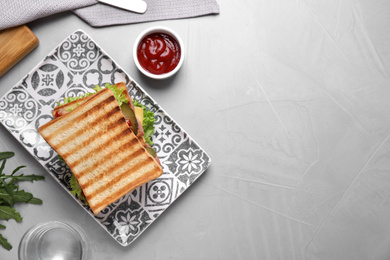 Tasty sandwich served on grey table, flat lay. Space for text