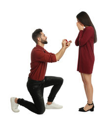 Man with engagement ring making marriage proposal to girlfriend on white background