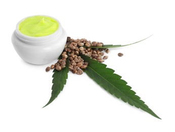 Jar with hemp cream, seeds and green leaf on white background. Natural cosmetics