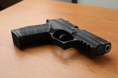 Semi-automatic pistol on wooden table. Standard handgun