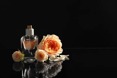 Photo of Elegant bottle of perfume and beautiful flowers on black background. Space for text