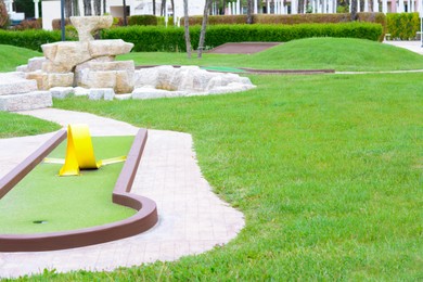 Green lawn with fresh grass, mini golf course and fountain outdoors