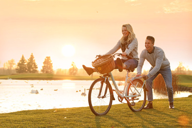Happy young couple with bicycle having fun outdoors. Time for picnic