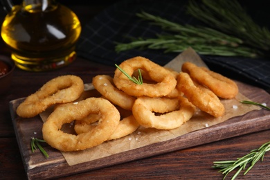 Fried onion rings served on wooden table