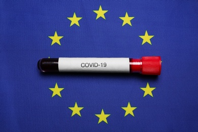 Test tube with blood sample on European Union flag background, top view. Coronavirus outbreak