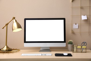 Photo of Stylish workplace with modern computer near beige wall indoors. Space for text