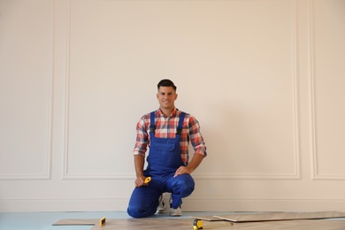 Professional worker installing new parquet flooring indoors