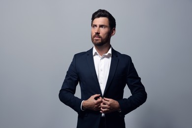 Photo of Portrait of handsome bearded man in suit looking away on light grey background