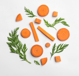 Cut carrot and leaves isolated on white, top view
