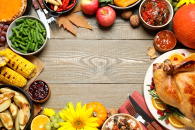 Traditional Thanksgiving day feast with delicious cooked turkey and other seasonal dishes served on wooden table, flat lay. Space for text
