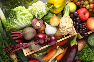 Photo of Different fresh vegetables and fruits with crate on grey wooden table, top view. Farmer harvesting