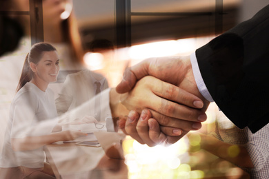 Double exposure of team workers and business partners shaking hands in office, closeup 