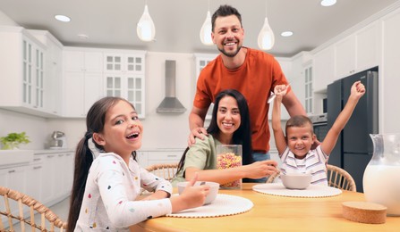 Happy family with children having fun during breakfast at home