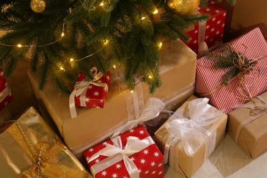 Gift boxes under Christmas tree with fairy lights