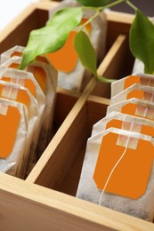 Paper tea bags with tags in wooden box , closeup
