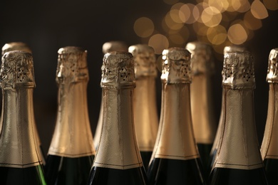 Many bottles of champagne on blurred background, closeup