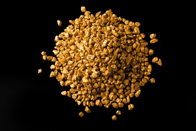 Pile of gold nuggets on black background, flat lay