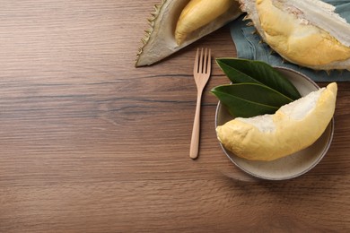Fresh ripe durians on wooden table, flat lay. Space for text