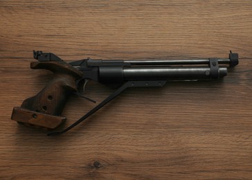 Gun shooting sport. Standard pistol on wooden table, top view