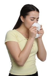 Sick young woman sneezing in tissue on white background. Cold symptoms