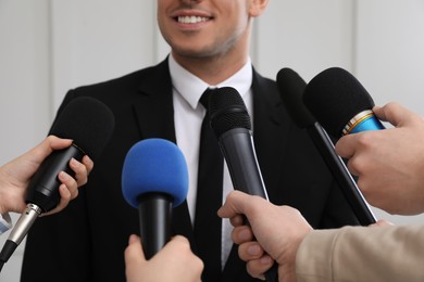 Happy business man giving interview to journalists at official event, closeup