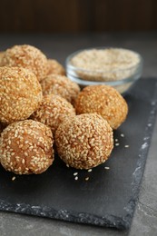 Photo of Many delicious sesame balls on grey table, closeup