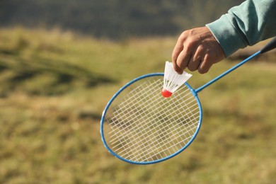 Man playing badminton outdoors on sunny day, closeup. Space for text