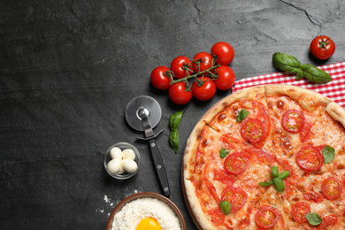 Photo of Delicious pizza Margherita and ingredients on dark grey table, flat lay. Space for text