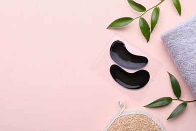 Flat lay composition with under eye patches on light pink background. Space for text