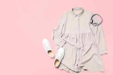 Stylish grey dress, shoes and headphones on pink background, flat lay. Space for text