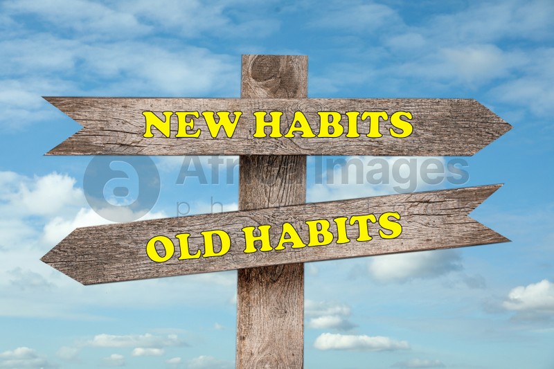 Signpost with two opposite directions to Old and New Habits outdoors