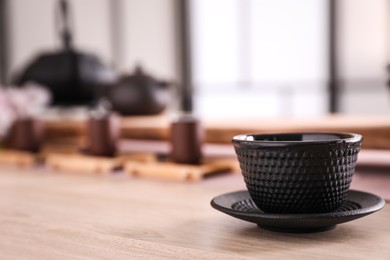 Cup with saucer for traditional tea ceremony on wooden table