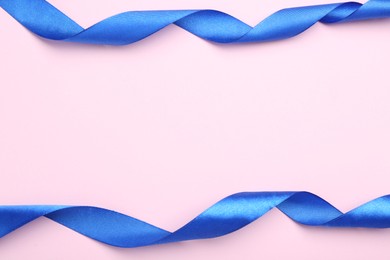 Photo of Beautiful blue ribbons on pink background, flat lay. Space for text