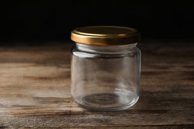 Closed empty glass jar on wooden table